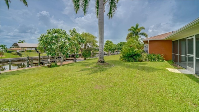 view of yard with a boat dock and a water view