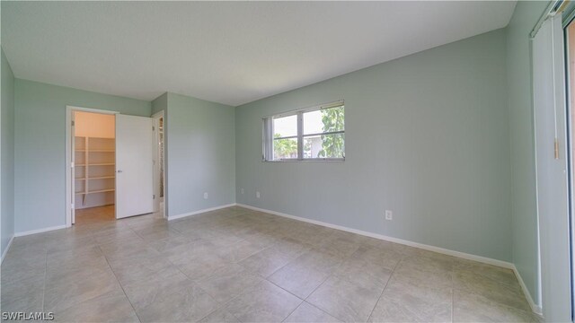 unfurnished bedroom with a spacious closet and a closet