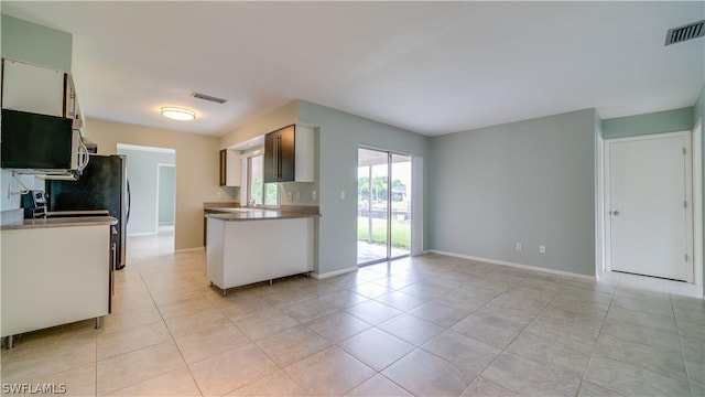 kitchen with light tile patterned flooring, sink, and white cabinets