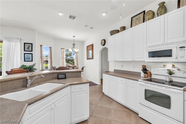 kitchen featuring white appliances, hanging light fixtures, light tile patterned floors, sink, and white cabinetry