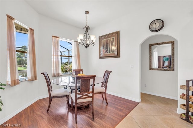 tiled dining room featuring an inviting chandelier