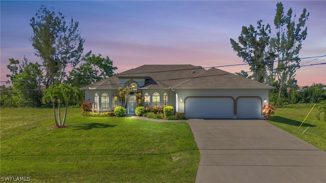 view of front of house featuring a yard and a garage