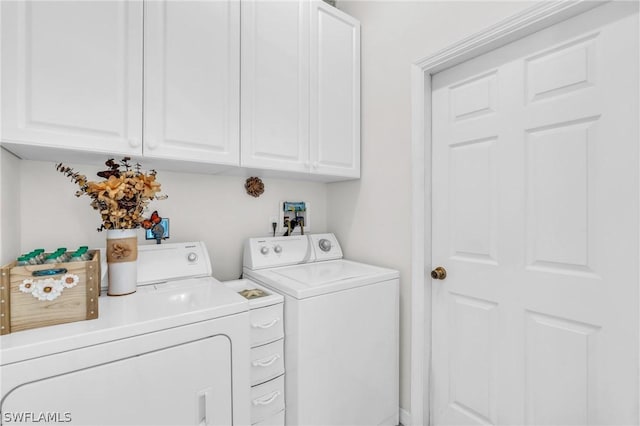 washroom featuring washer and dryer and cabinets