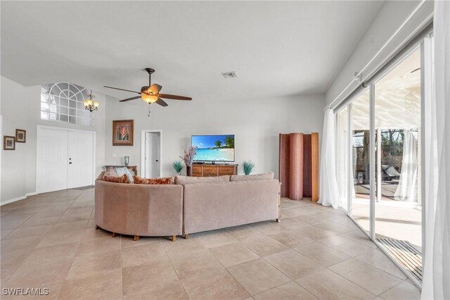 tiled living room featuring ceiling fan with notable chandelier