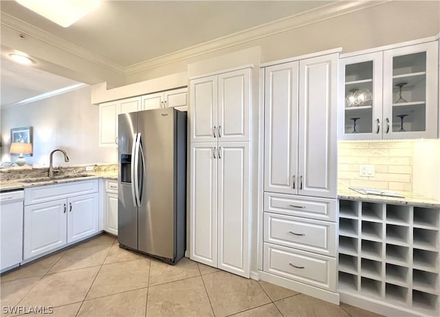 kitchen with light stone counters, light tile patterned floors, ornamental molding, a sink, and stainless steel fridge with ice dispenser