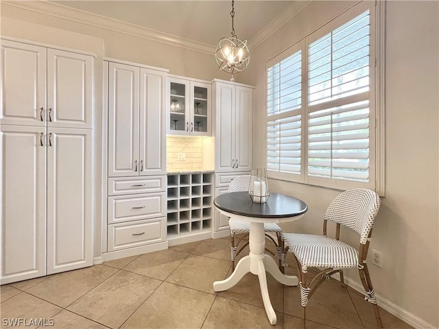 dining area featuring ornamental molding, a chandelier, baseboards, and light tile patterned floors