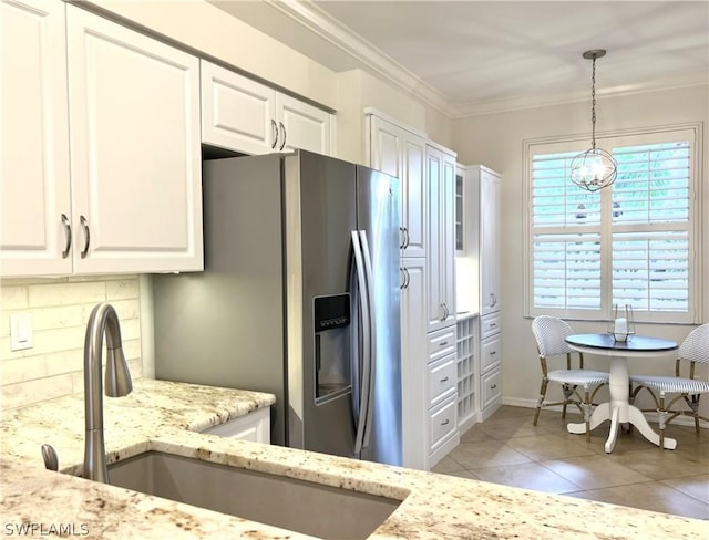 kitchen with white cabinets, a sink, backsplash, and crown molding