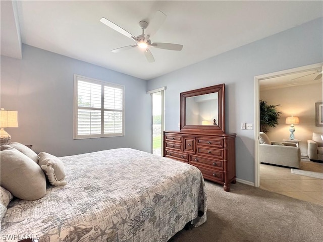 bedroom with a ceiling fan, light colored carpet, and baseboards