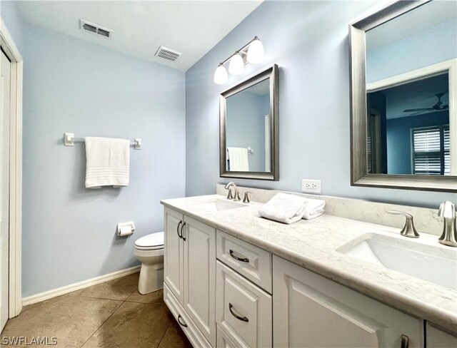 bathroom with dual vanity, tile patterned flooring, ceiling fan, and toilet