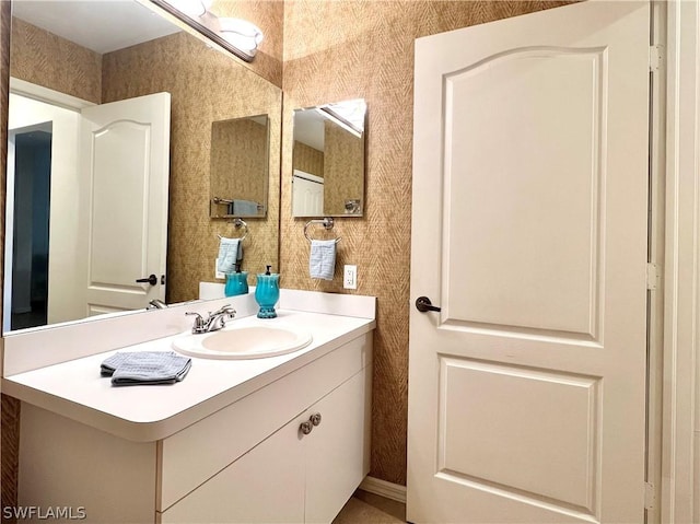 bathroom with wallpapered walls and vanity