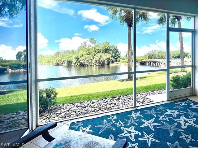 sunroom / solarium featuring a water view and plenty of natural light