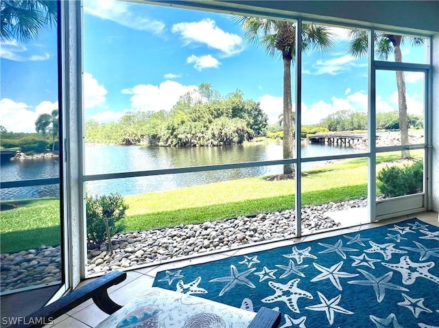 sunroom / solarium featuring a water view