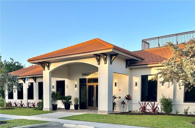 view of front of property featuring a front lawn and stucco siding