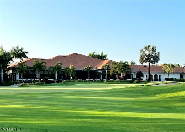 view of community with view of golf course and a lawn