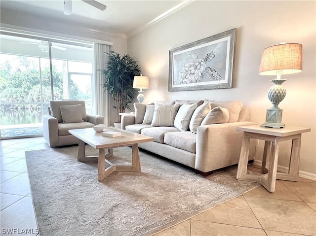 living room with light tile patterned floors, a ceiling fan, baseboards, and crown molding