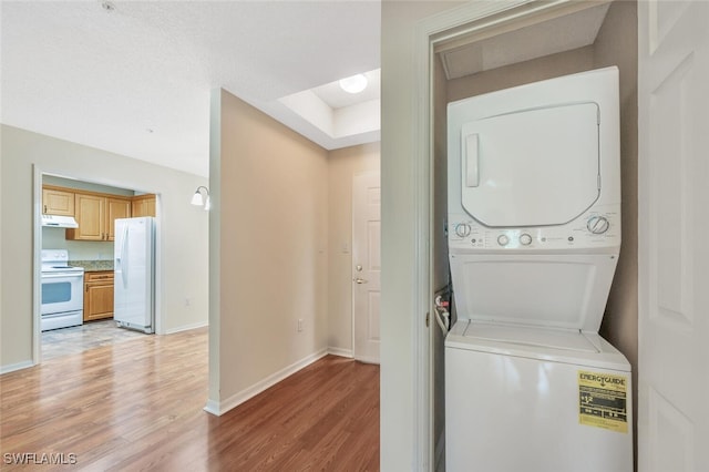900 Arbor Lake Dr Unit 206, Naples, FL 34110 - washroom with stacked washer / drying machine and hardwood / wood-style floors