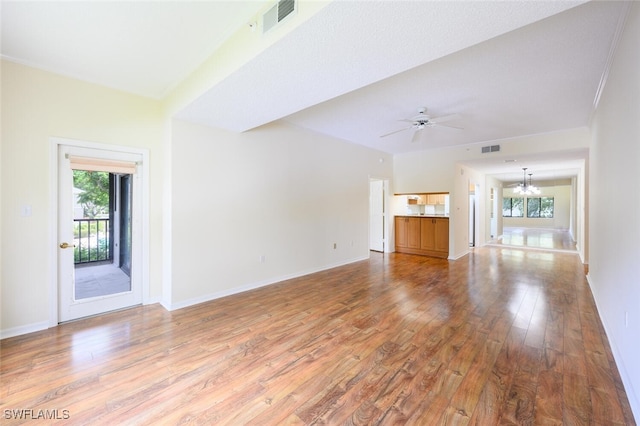 900 Arbor Lake Dr Unit 206, Naples, FL 34110 - unfurnished living room with ceiling fan with notable chandelier, a healthy amount of sunlight, and hardwood / wood-style floors