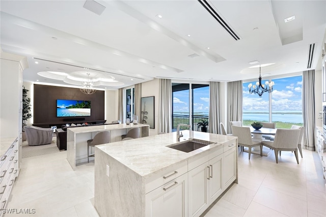 4800 Pelican Colony Blvd Unit Ph2103, Bonita Springs, FL 34134 - kitchen featuring a chandelier, an island with sink, a sink, light stone countertops, and a wall of windows