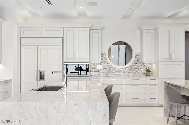 4800 Pelican Colony Blvd Unit Ph2103, Bonita Springs, FL 34134 - kitchen with a sink, paneled fridge, backsplash, light stone countertops, and white cabinetry