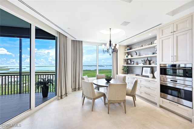 dining room featuring a water view, floor to ceiling windows, and a notable chandelier