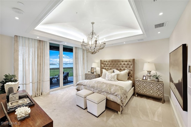 carpeted bedroom featuring a raised ceiling, an inviting chandelier, access to exterior, ornamental molding, and a water view