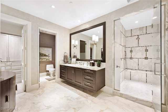 bathroom featuring a shower with shower door, toilet, and vanity