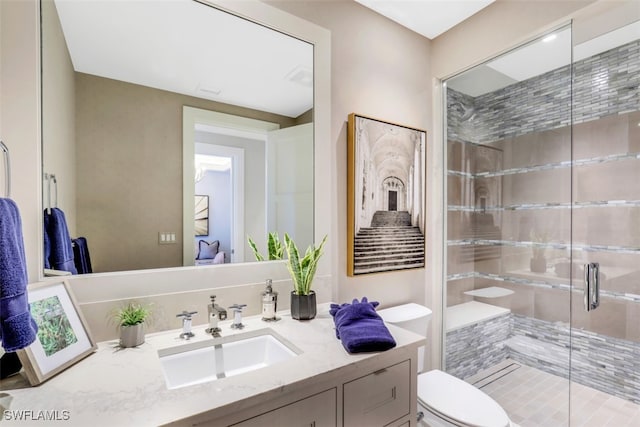 bathroom featuring an enclosed shower, toilet, and vanity