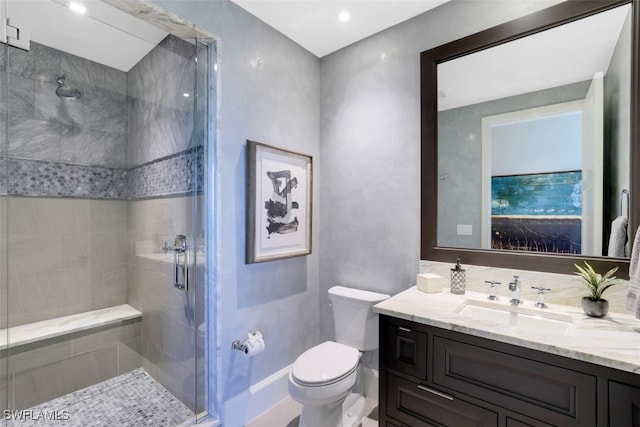 bathroom featuring vanity, toilet, and an enclosed shower