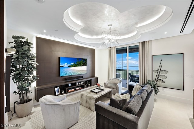 living room with an inviting chandelier and a raised ceiling