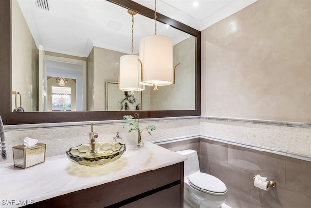 bathroom featuring vanity, toilet, and tile walls