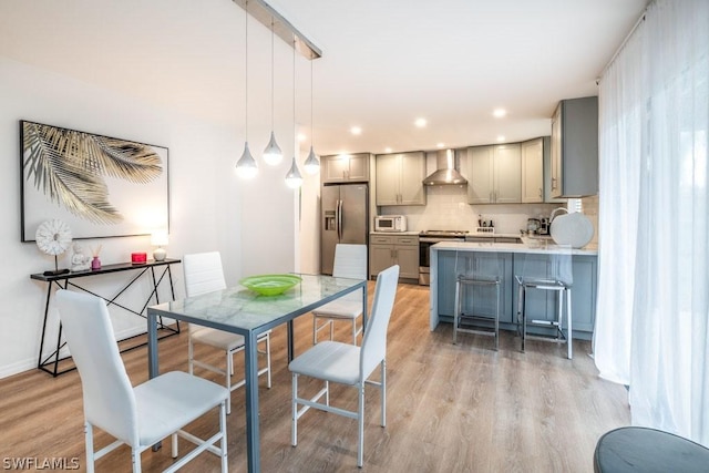 dining room featuring recessed lighting, light wood-style flooring, and baseboards