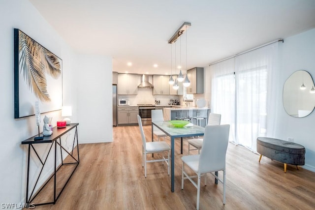 dining area with light wood-type flooring, baseboards, and recessed lighting