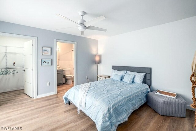 bedroom with ceiling fan, ensuite bathroom, and light wood-type flooring