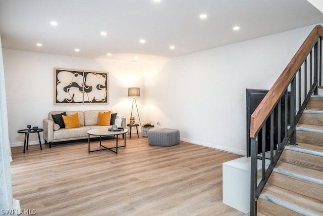 living room featuring light wood-style floors, recessed lighting, stairway, and baseboards