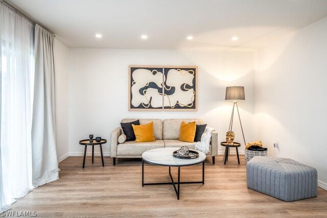 living area with recessed lighting, light wood-style flooring, and baseboards