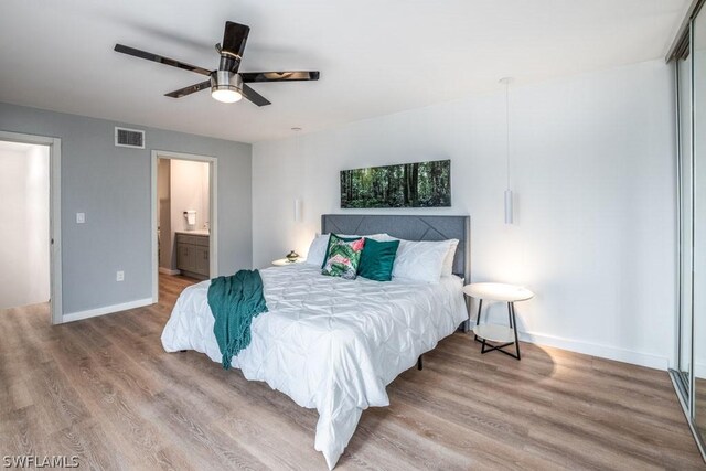 bedroom featuring wood-type flooring, ensuite bathroom, and ceiling fan