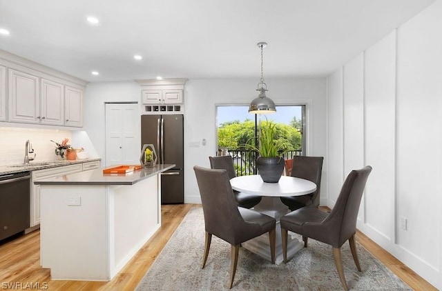 dining space with sink and light hardwood / wood-style floors