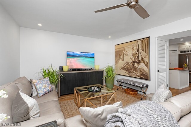 living room with ceiling fan and light hardwood / wood-style flooring