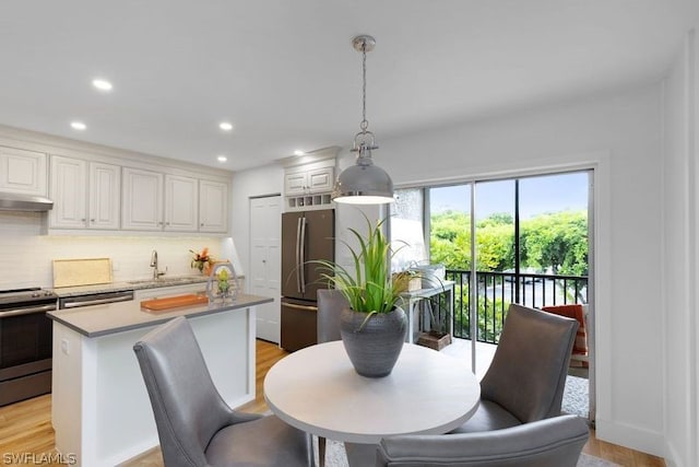 dining space featuring sink and light wood-type flooring