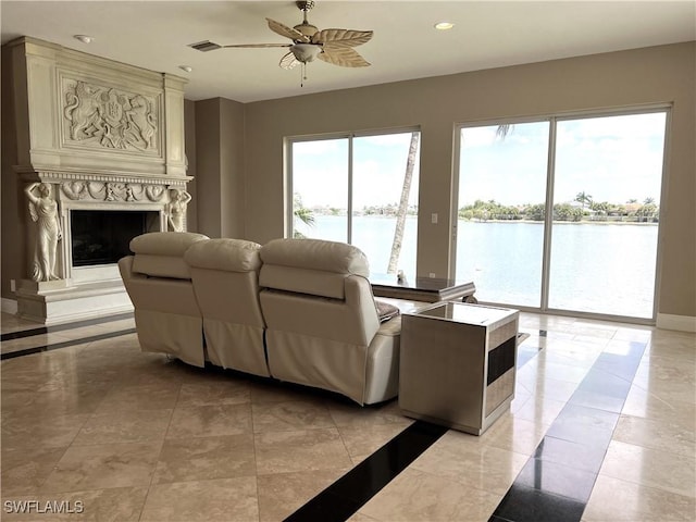 living room featuring a water view, ceiling fan, and a premium fireplace