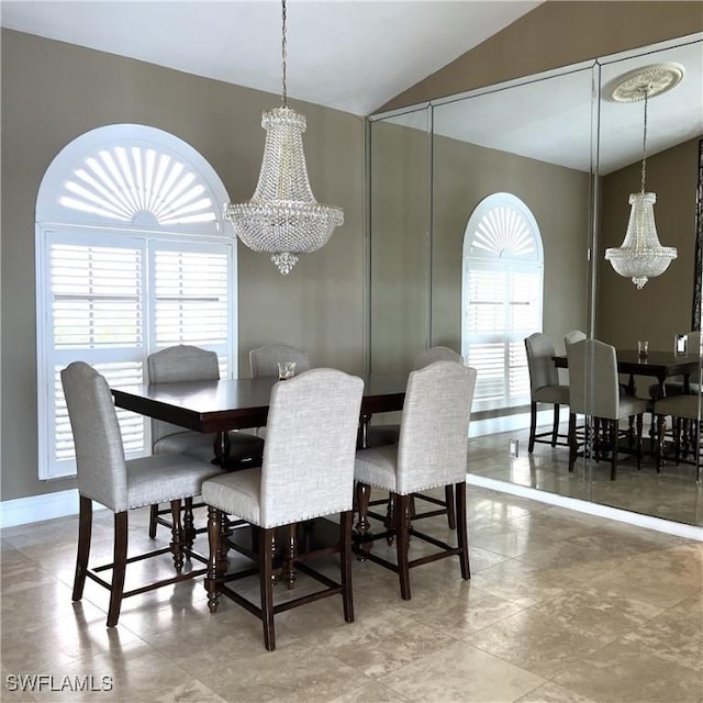 dining area featuring lofted ceiling, a healthy amount of sunlight, and an inviting chandelier