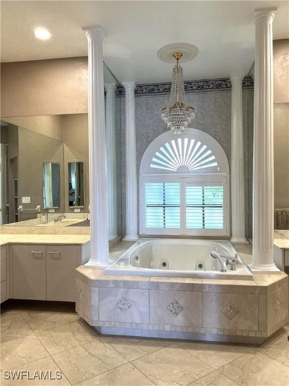 bathroom with vanity, decorative columns, and tiled tub