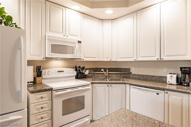 kitchen featuring sink, white appliances, and white cabinets