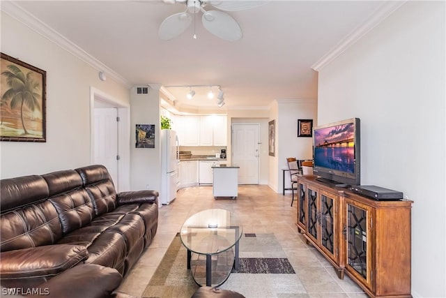 tiled living room featuring track lighting, ornamental molding, and ceiling fan