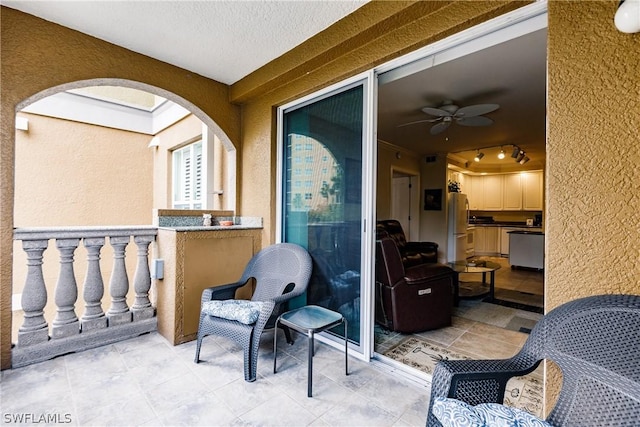 view of patio featuring ceiling fan and a balcony