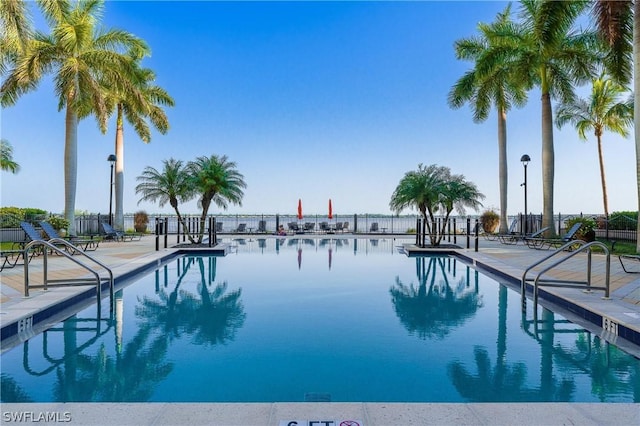 view of swimming pool with a patio and a water view