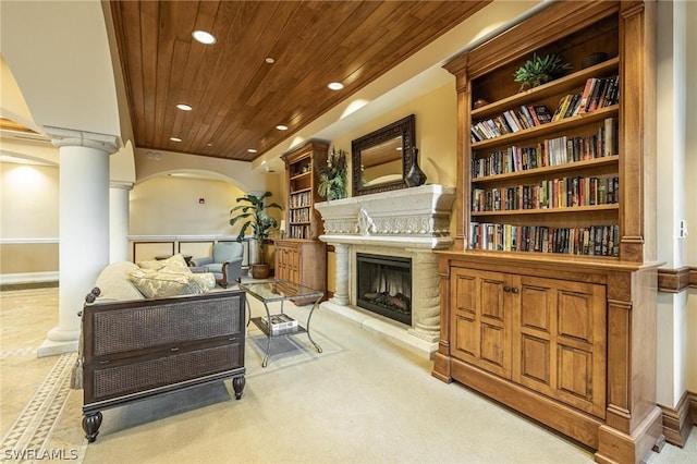 carpeted living room with wooden ceiling and decorative columns