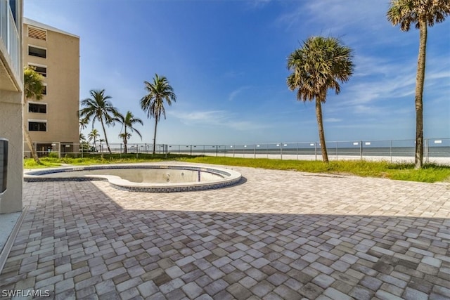 surrounding community with a water view, a patio area, and a pool