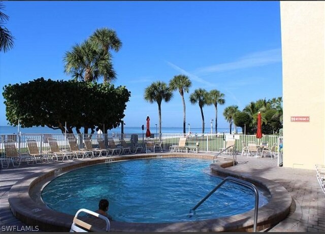 view of pool with a patio area and a water view