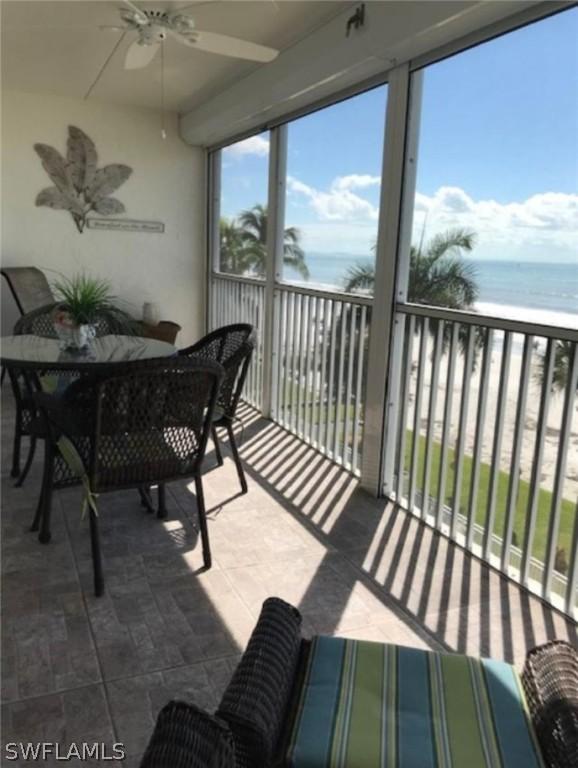 sunroom / solarium with a water view and ceiling fan